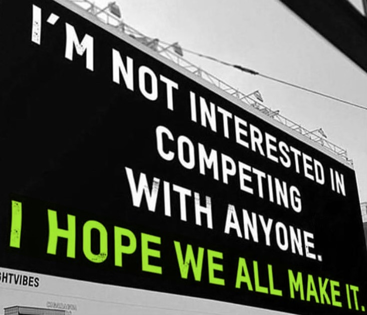 billboard reads "I'm not interested in competing with anyone. I hope we all make it."